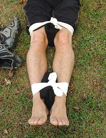 Attachez soigneusement les jambes ensemble, en veillant à ne pas attacher les bandages sur le site de la blessure ou sur les genoux.  L'idée est de maintenir la jambe blessée immobilisée, en la fixant à la jambe non blessée