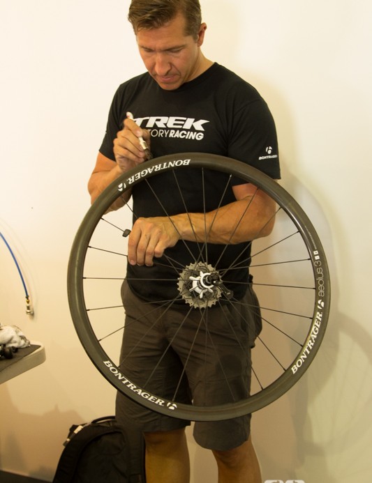 Un mécanicien de Trek Factory Racing prépare une jante pour un nouveau pneu