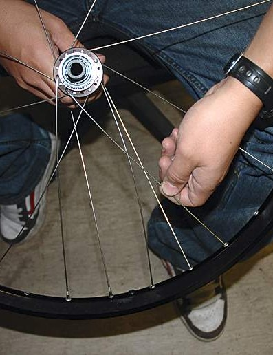 Complétez ce côté de la roue en insérant un rayon à travers la bride deux trous dans le sens inverse des aiguilles d'une montre à partir de celui déjà vers le haut.