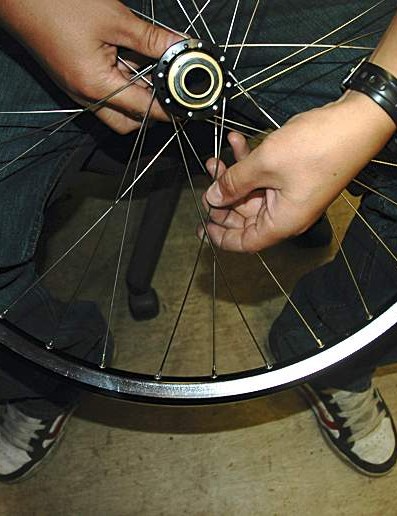 Mettez le rayon dans la jante à quatre œillets dans le sens des aiguilles d'une montre à partir du trou de valve, en laçant sur deux rayons et sous un troisième.