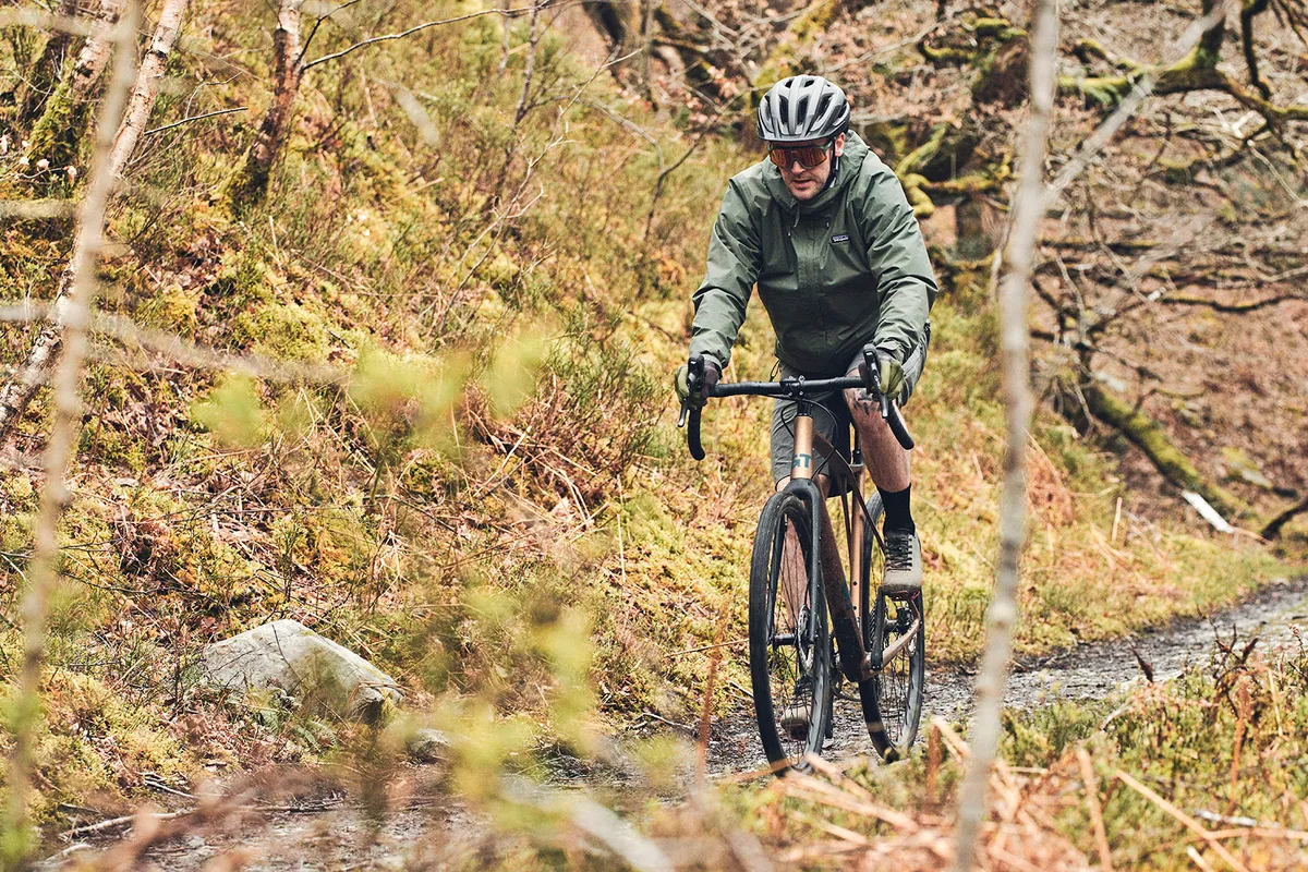 Cycliste masculin en veste verte chevauchant le vélo de gravier GT Grade Carbon Pro LE