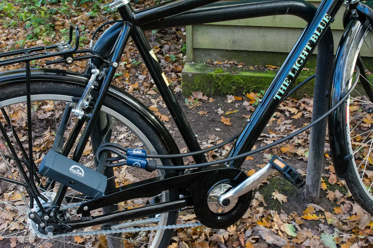 Vélo verrouillé avec un cadenas Squire D et un câble antivol