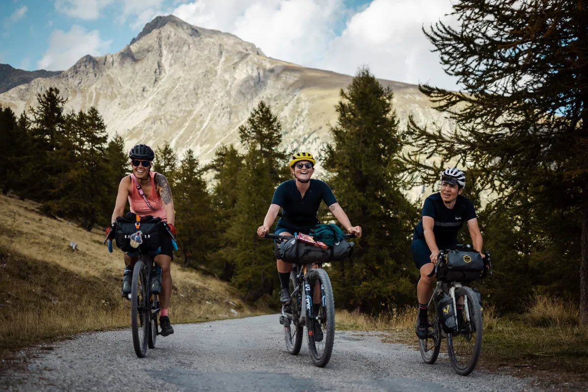 Groupe de trois cyclistes féminines grimpant sur des vélos chargés