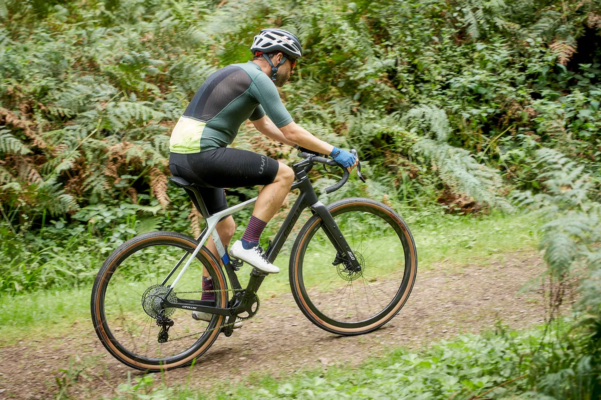 Cycliste masculin en haut vert équitation le vélo de gravier Cipollini Ago