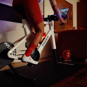 A cyclists rides the Zwift Ride smart bike in a living room