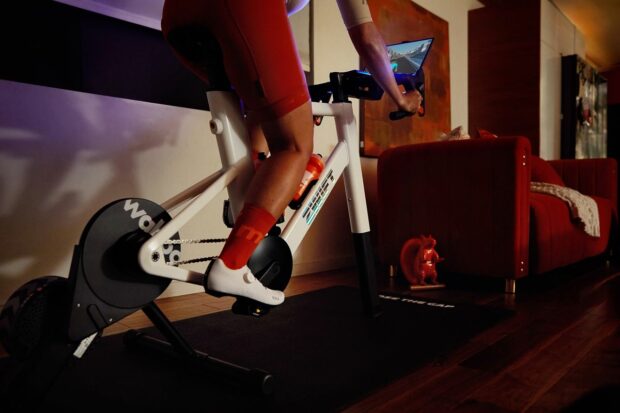 A cyclists rides the Zwift Ride smart bike in a living room