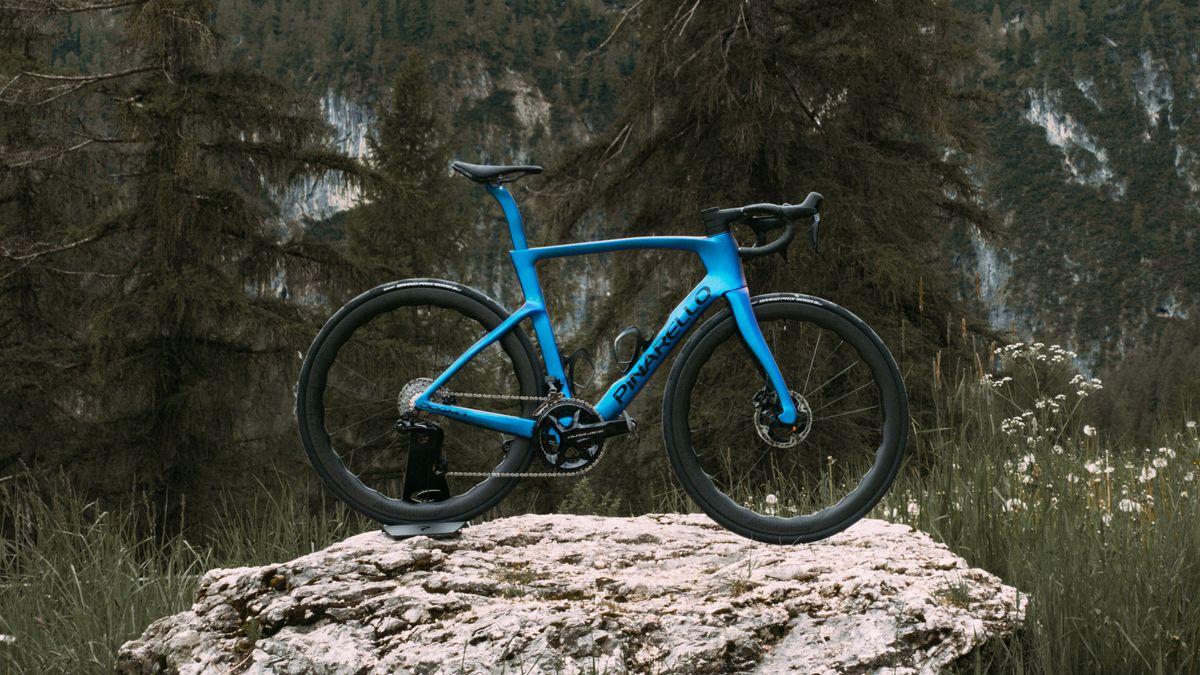 A blue Pinarello Dogma F stands on a rock