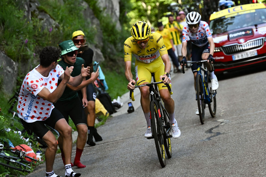 Le coureur slovène de l'équipe UAE Team Emirates, Tadej Pogacar, portant le maillot jaune de leader du classement général (à gauche), prend la tête devant le coureur danois Jonas Vingegaard (à droite) de l'équipe Team Visma - Lease a Bike dans l'ascension finale du Plateau de Beille lors de la 15e étape de la 111e édition du Tour de France cycliste, 197,7 km entre Loudenvielle et Plateau de Beille, dans les Pyrénées, dans le sud-ouest de la France, le 14 juillet 2024. (Photo de Marco BERTORELLO / AFP)