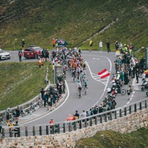 Spectators watch as the pack of cyclists ride past in a mountain area during the 4th stage from St. Johann Alpendorf to Kals am GroÃglockner (151,7 km) of the 2024 Tour of Austria on July 6, 2024. (Photo by Johann GRODER / various sources / AFP) / Austria OUT