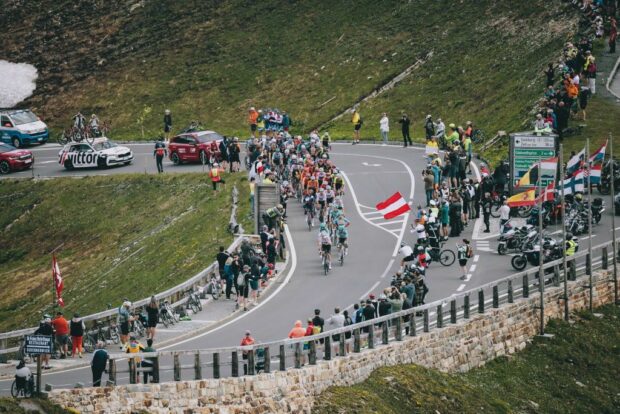 Spectators watch as the pack of cyclists ride past in a mountain area during the 4th stage from St. Johann Alpendorf to Kals am GroÃglockner (151,7 km) of the 2024 Tour of Austria on July 6, 2024. (Photo by Johann GRODER / various sources / AFP) / Austria OUT