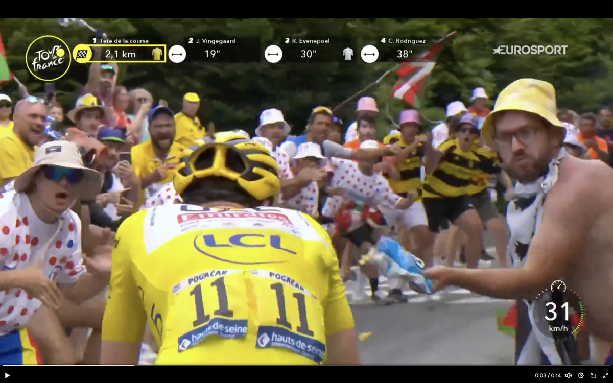 A television frame of the moment a spectator threw chips at Tadej Pogačar