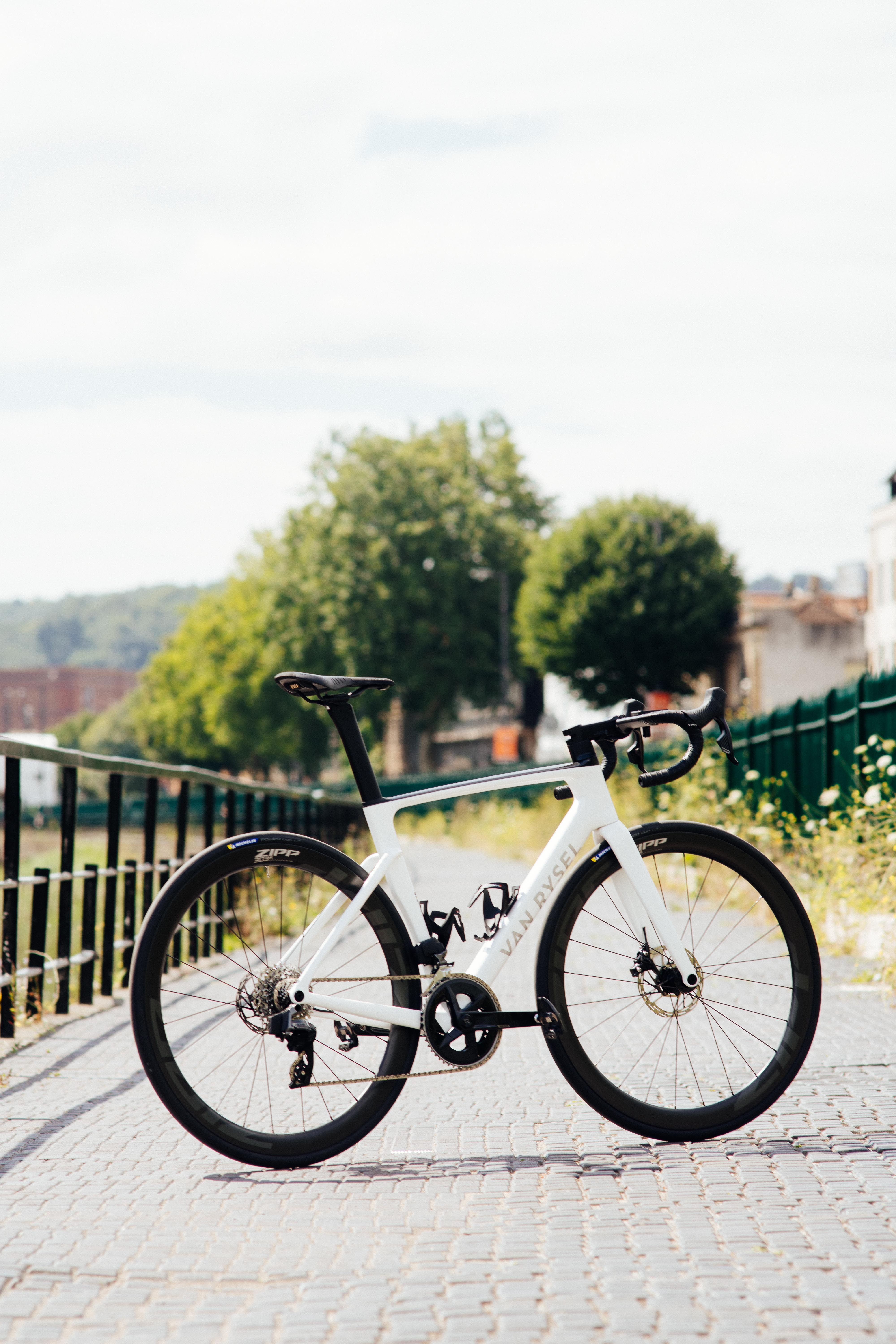 Un vélo blanc à 45 degrés sur une piste cyclable au soleil