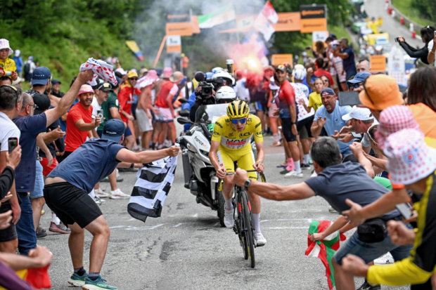 Tadej Pogačar rides through the crowds on stage 14 of the Tour de France