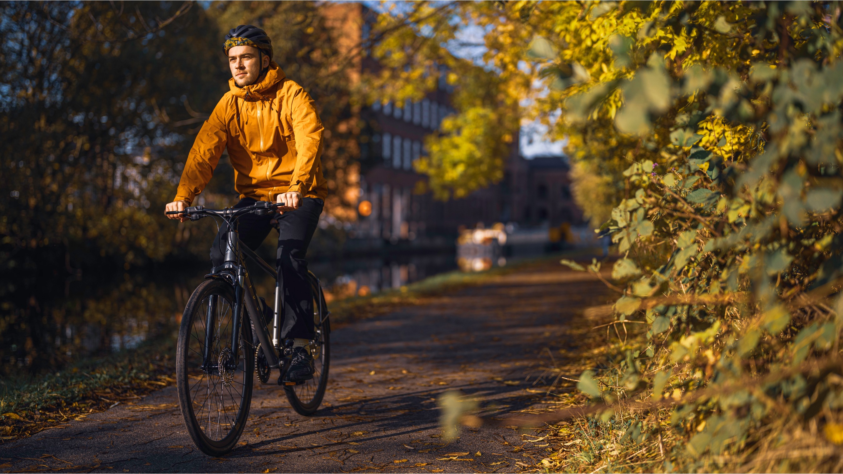 Une photo de style de vie d'un homme conduisant un hybride Ribble dans un environnement verdoyant