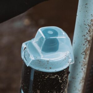 A close up of a water bottle with a cap in a bike frame