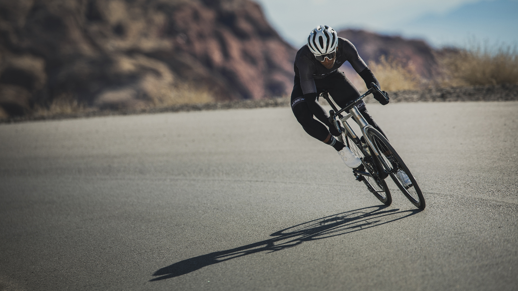 Un cycliste traversant un virage large et lisse sur le tarmac