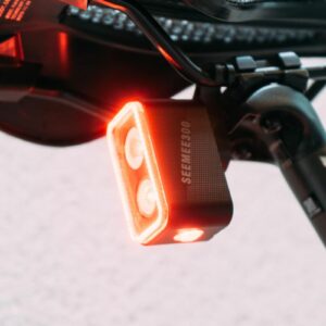 A close up of the Magicshine Seemee300 rear bike light with two bulbs and one bulb underneath