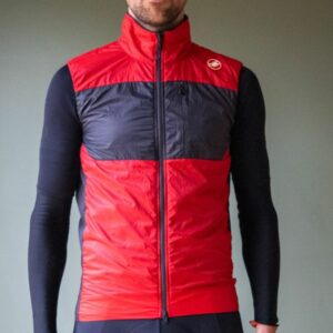 A male cyclist wearing a red Castelli Unlimited Puffy vest