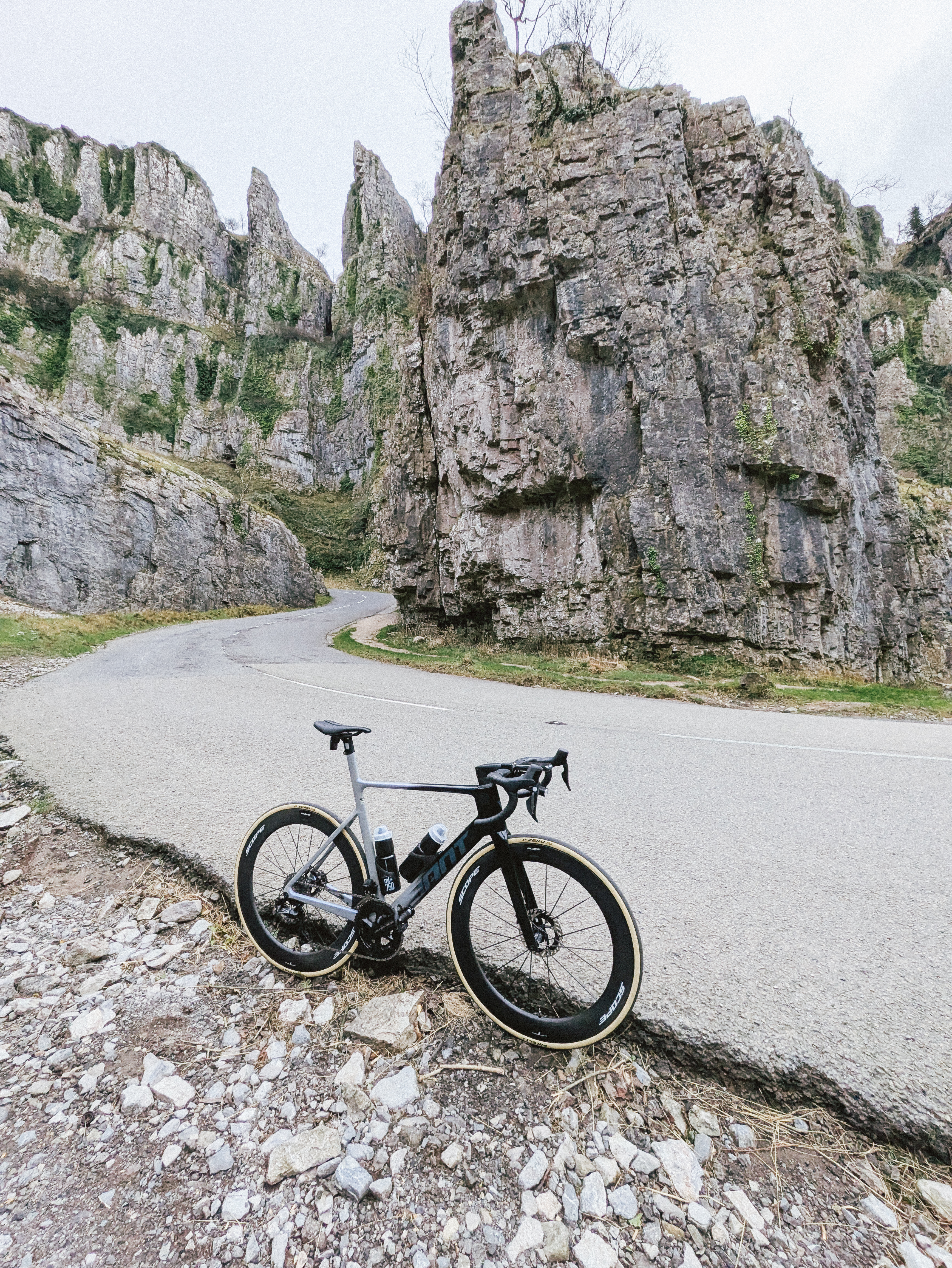 Un vélo aérodynamique doté de roues profondes se dresse sur une épingle à cheveux dans une gorge aux parois abruptes.