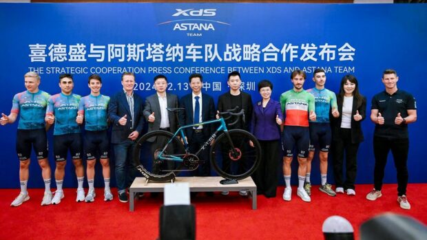 XDS management and XDS Astana team members stood behind the team X Lab bike at the presentation in China