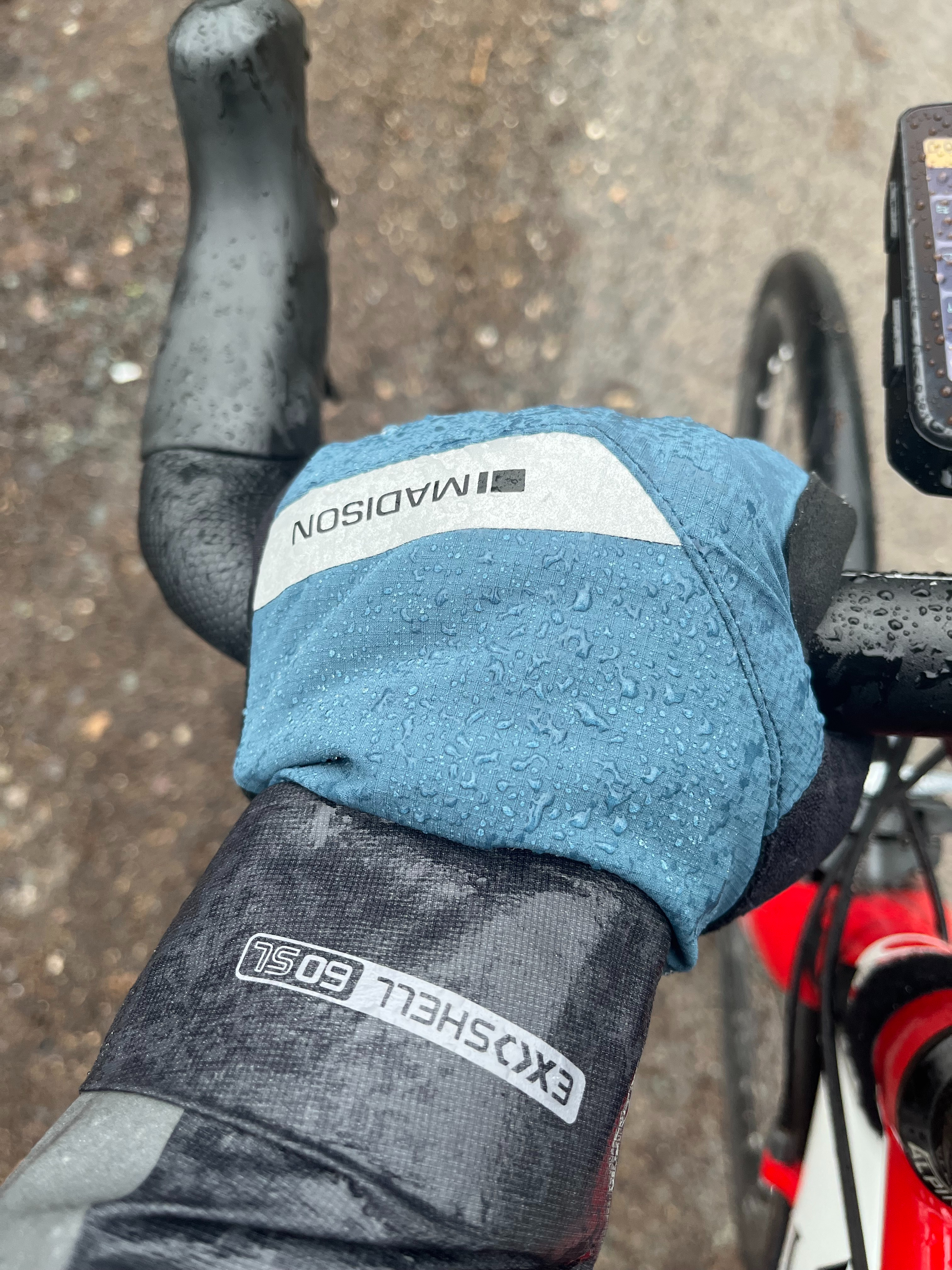 Un pilote portant des gants d'hiver Madison DTE tenant le guidon sous la pluie