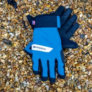 A pair of blue Madison DTE waterproof gloves on gravel