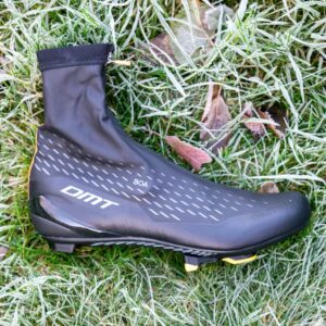 A dirty DMT WKR1 cycling shoe on some frosty grass