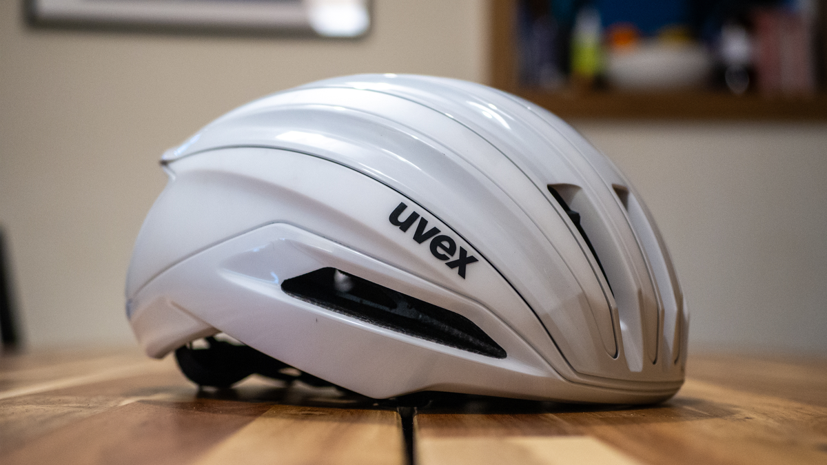 A white Uvex Surge helmet stands on a wooden table