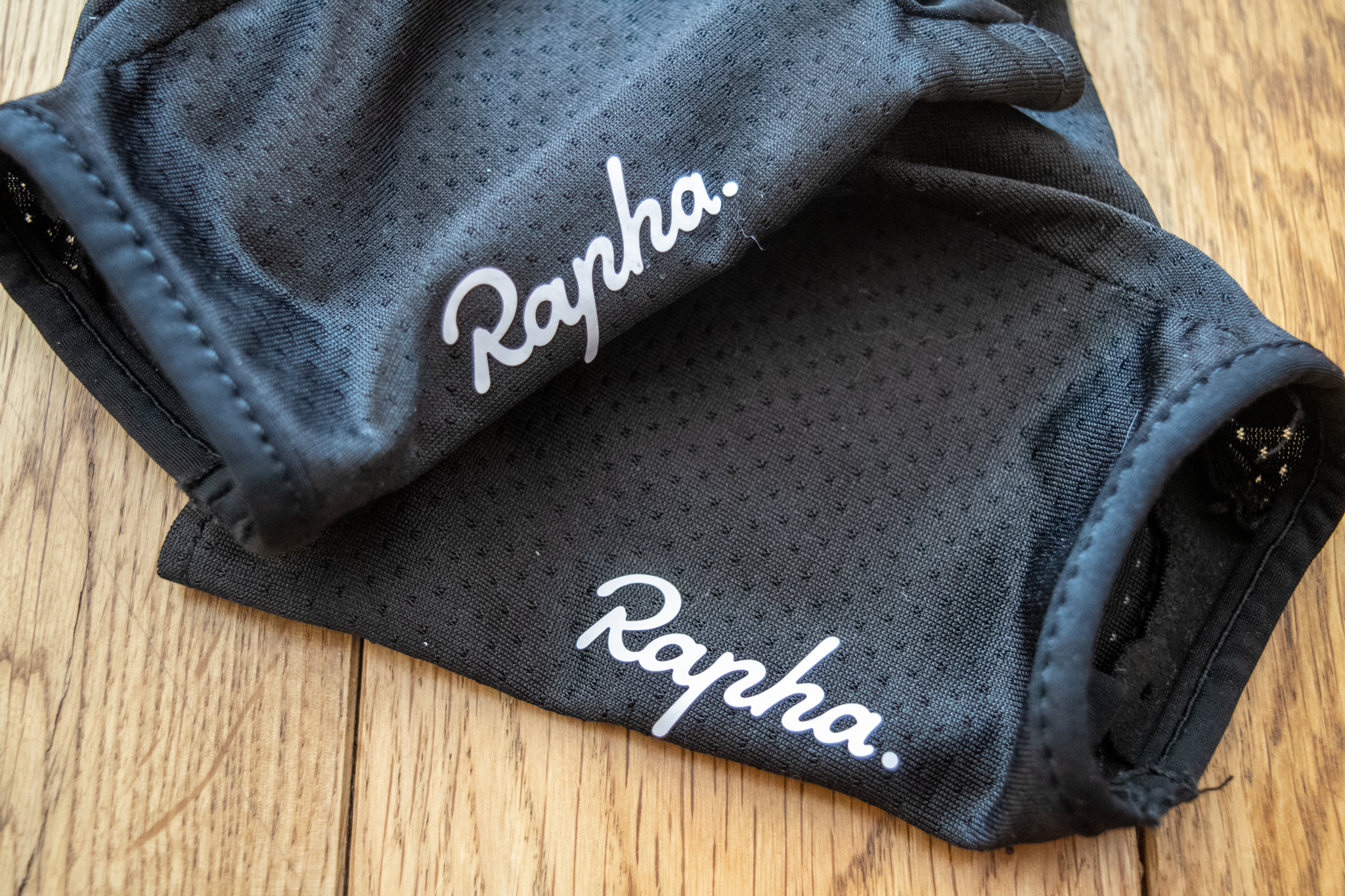 Un gant à cyclisme noire Rapha sur un plancher en bois