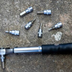 An M Part torque wrench and hex bits on a concrete floor