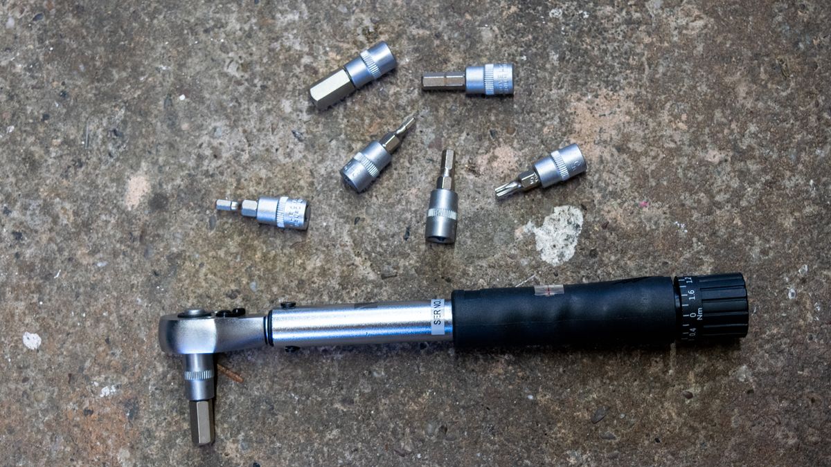 An M Part torque wrench and hex bits on a concrete floor